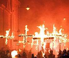 A photograph of people carrying flaming martyrs crosses in Lewes during the bonfire night celebration