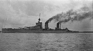 Three-stacked, dark grey warship at sea