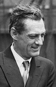 Black and white photo of Lionel Barrymore—a middle-aged white man in profile, with straight hair, wearing a sophisticated suit and smiling, in 1923.