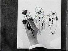 Film still of a hand sketching three cartoon characters