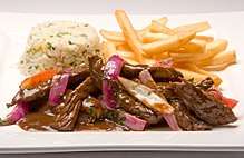 Lomo saltado with onions, tomatoes, french fries and white rice