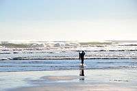 Lone surfer on Piha Beach, Auckland, NZ