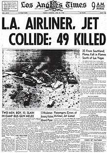 Newspaper front page. Headline states in large font "L.A. AIRLINE, JET COLLIDE; 49 KILLED. An aerial photo of the desert crash site is immediately below the headline. The photo shows emergency vehicles surrounding shattered and burned wreckage from which dark smoke rises.
