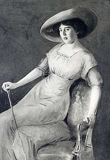 Painting of a dark-haired woman of about 30 posing on the edge of an upholstered chair with the help of a decorative walking stick. She is wearing an elegant full-length gown and a wide-brimmed hat.