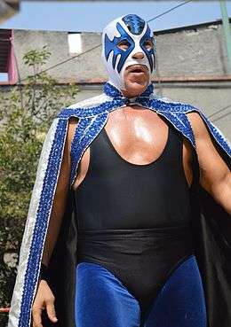 Masked wrestler Atlantis in the ring during an outdoor wrestling event.
