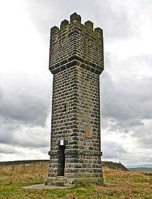  A brick tower, about 11 meters high, against a cloudy background. The tower has a square base. At the top, there are 3 battlements visible.