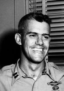 A black-and-white photo of Humbert Versace wearing his military uniform. Two military badges are clearly visible on the left breast pocket.