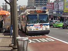Curbside, red-painted bus lanes on Fordham Road in the Bronx