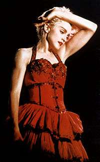 Madonna in a red dress and short blond hair, looking down