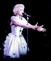 Madonna in a sky blue dress singing onstage.