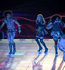 Madonna, in high heels, dancing onstage with three other people