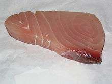 Approximately triangular piece of pink-to-red fish