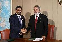 Two smiling men in business suits, shaking hands