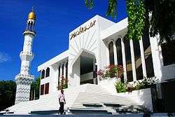 A white mosque under a blue sky.