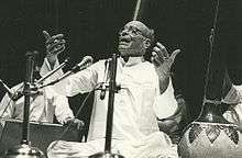 Black and white photograph of an old man singing.