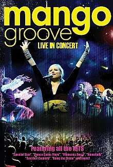 Front cover: A photograph of lead singer Claire Johnston with her arms raised. She is flanked by photos of Mango Groove singers and dancers. Below her is a photo of the audience in silhouette. The cover has a dark blue-and-black colour scheme. Above the photos the words 'Mango Groove: Live in Concert' are set in large, yellow type.