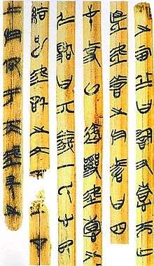 Photograph of strips of bamboo with vertical writing in an early Chinese seal script