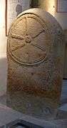 10th- or 11th-century carved stone slab, showing a cross in the style of a cart-wheel.