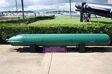 Submarine torperdo on outside display win a naval museum located neat the shore