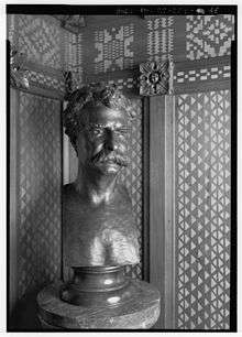 A bronze bust of Mark Twain on a pedestal