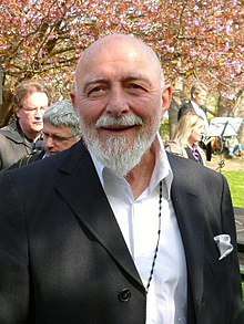a smiling elderly man, bald and white-bearded