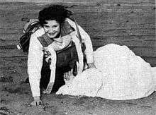 Mary L. Redfern was the first member of the WAVES to make the jump required for the completion of the parachute riggers course, at the Naval Air Station in Lakehurst, New Jersey. She is shown on the ground smiling and untangling her parachute.