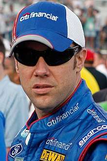 Man in his late thirties wearing a blue and white baseball cap with black sunglasses covering his eyes