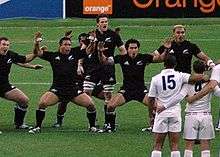 McCaw in the middle of the New Zealand haka facing a line of the French team in white
