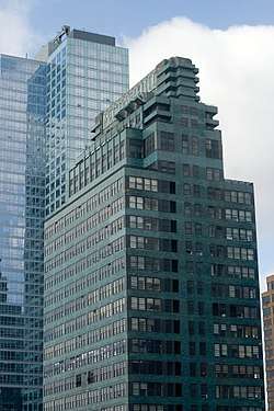 Tall green building with the words "McGraw-Hill" across the top floors, with a taller glass building behind