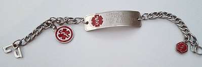 A metal bracelet, engraved with a short list of important medical information, and decorated with a red symbol representing medicine