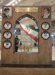 Indoor memorial, with photos and an Iranian flag