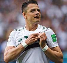 Javier Hernández, in his Mexico national team uniform, holds the team's crest on his chest