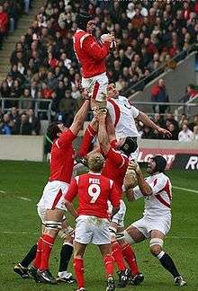  A Welsh player grasping the ball while being held in the air by his team-mates following a line-out