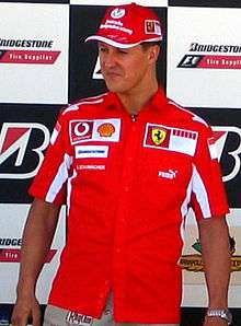 A man in his late thirties wearing a red T-shirt emblazoned with the Ferrari logo.