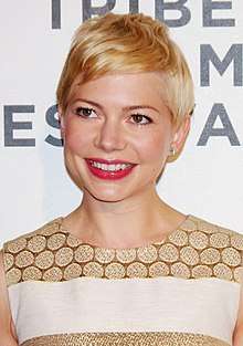 A head shot of Michelle Williams as she smiles looking slightly away from the camera