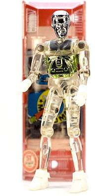 A photo of a vintage Microman M101 (George) 3.75-inch-tall (9.5&nbsp;cm) action figure with capsule in the background.