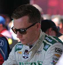 Driver Mike Conway, in uniform and dark glasses