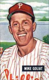 A smiling man in a red baseball cap with a white "P" on the face and a white baseball jersey with red pinstripes and "Phillies" (obscured) across the chest in red