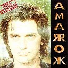 The Amarok album cover. It shows a photograph of Oldfield's face along with a red stamp containing his name at the top left. On the right side arranged vertically is the name Amarok in gold coloured capital letters; the letters A, M and O appear normally, but R and K are mirrored about the vertical stroke of the letter.