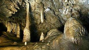 Stalactites, stalagmites, and a column of dripstone in a large cave chamber called Miller's Chapel