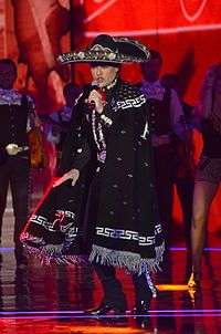 singer in charro outfit singing.