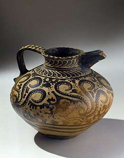 Small, painted jug with a spout and handle