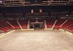An empty arena with the sheet of ice and the score board