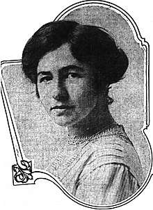 Shoulder-length formal portrait of a dark-haired woman in her late 20s.