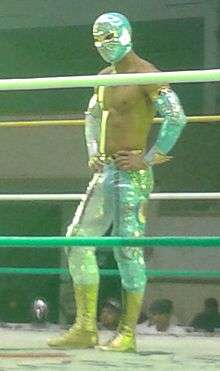 Masked wrestler Místico standing in a wrestling ring.