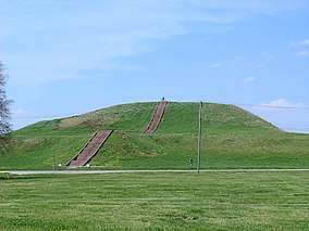 Large grassy mound. A flight of steps leads to the top of the mound.