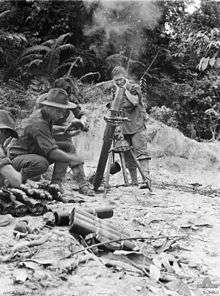 Soldiers operating a mortar amidst a jungle scene