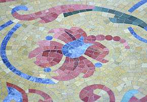 The multi-colored mosaic floor tiles, showing flowing flowery patterns.