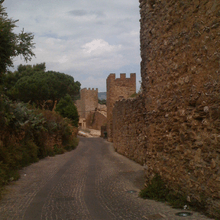 Walls and towers along a narrow, curved street