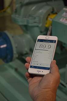 An image of a person holding a smartphone displaying the NIOSH sound level meter application (app)